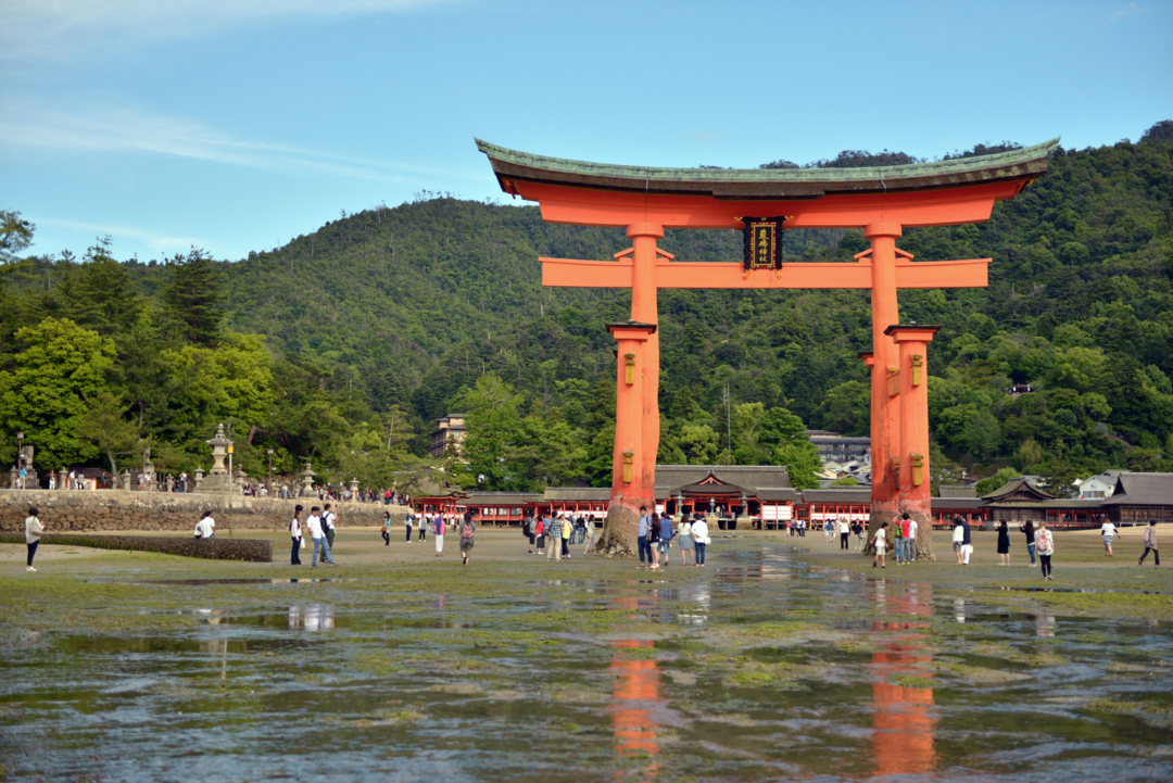 People walking near the Otorii gate of Itsukushima Shrine at low tide